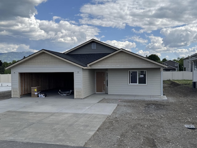 18420 E 1st Ln, Spokane Valley, WA 99016 - ranch-style home with an attached garage, driveway, a mountain view, and a shingled roof