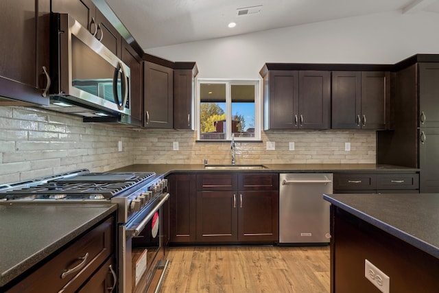 18420 E 1st Ln, Spokane Valley, WA 99016 - kitchen featuring appliances with stainless steel finishes, lofted ceiling, a sink, dark countertops, and backsplash
