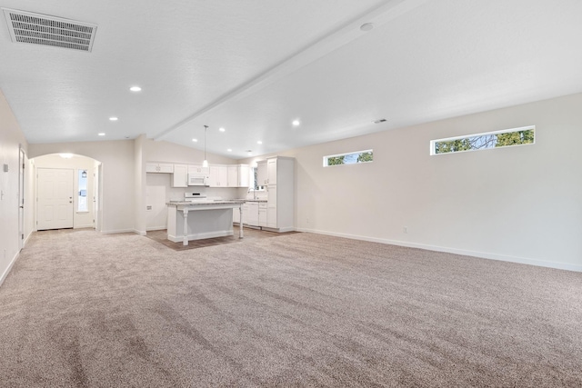 18420 E 1st Ln, Spokane Valley, WA 99016 - unfurnished living room with light carpet, lofted ceiling, baseboards, recessed lighting, and arched walkways