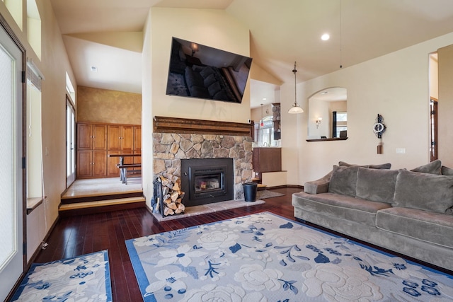 21718 W Watt Rd, Cheney, WA 99004 - living area with wood-type flooring, a stone fireplace, high vaulted ceiling, baseboards, and arched walkways