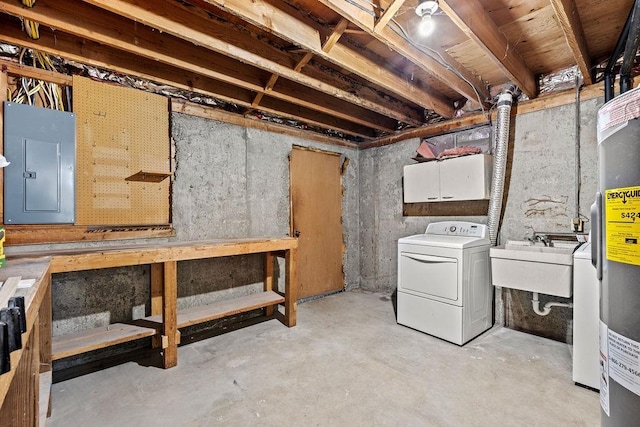 unfinished basement with electric panel, a sink, water heater, and washing machine and dryer