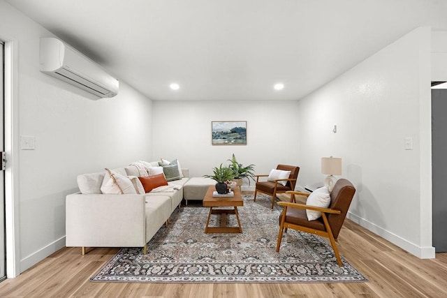 living room with a wall mounted air conditioner, baseboards, light wood finished floors, and recessed lighting