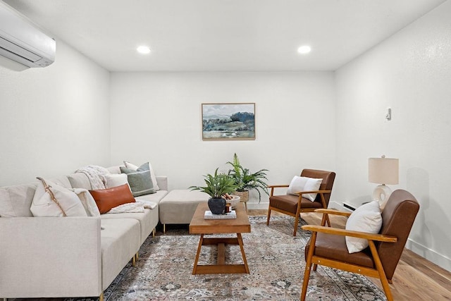living room with a wall mounted air conditioner, wood finished floors, recessed lighting, and baseboards