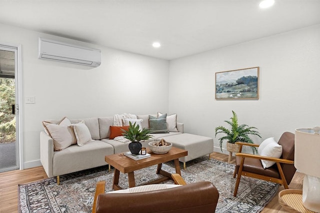 living room with a wall mounted AC, light wood-type flooring, baseboards, and recessed lighting
