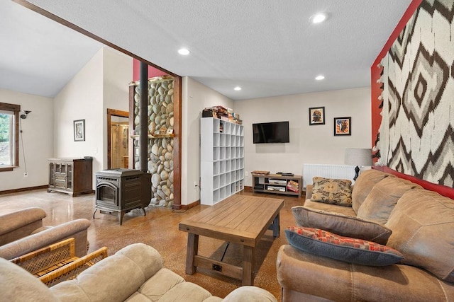 living room with baseboards, a wood stove, recessed lighting, and a textured ceiling