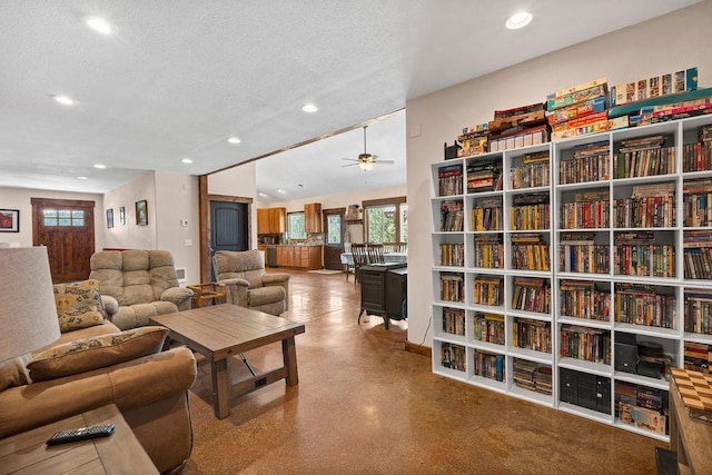 living area with recessed lighting, ceiling fan, and a textured ceiling