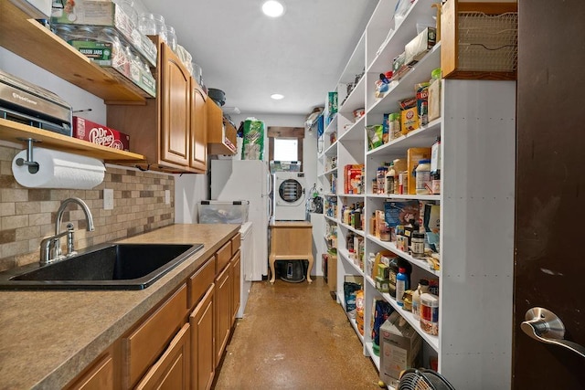storage area featuring a sink and washer / clothes dryer