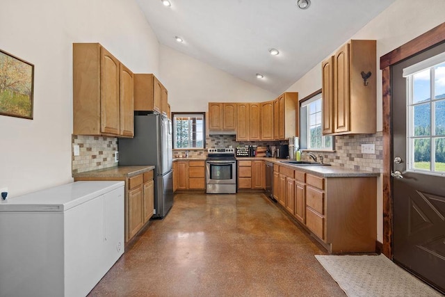 kitchen with appliances with stainless steel finishes, backsplash, a sink, healthy amount of natural light, and recessed lighting