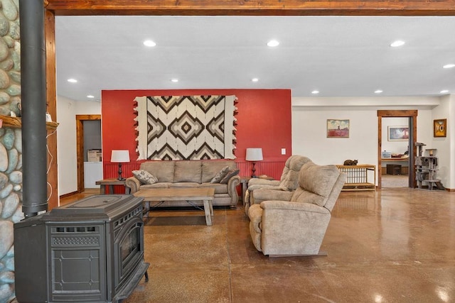 living area featuring a wood stove, concrete floors, and recessed lighting