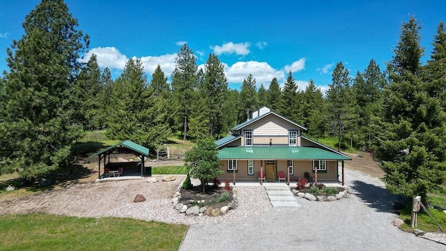view of home's community with driveway, a carport, and a wooded view