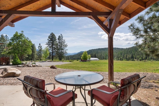 view of patio / terrace with a wooded view, a mountain view, and a gazebo