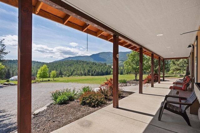 view of patio / terrace featuring a mountain view and a wooded view