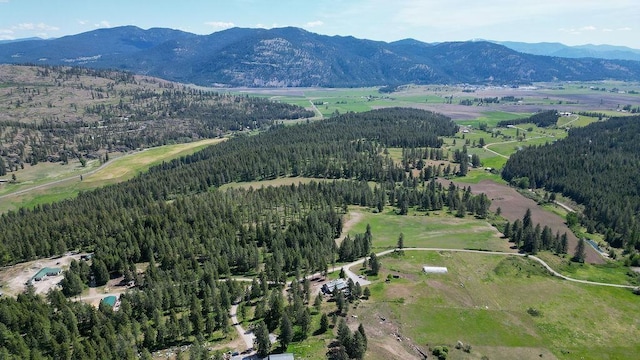 aerial overview of property's location with a mountain backdrop and a heavily wooded area
