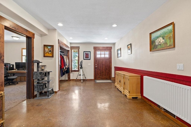 foyer entrance featuring radiator heating unit and recessed lighting