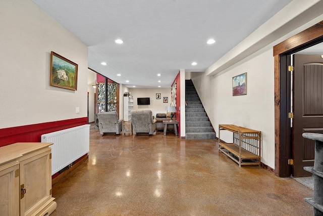 hall with radiator, stairway, a wainscoted wall, and recessed lighting