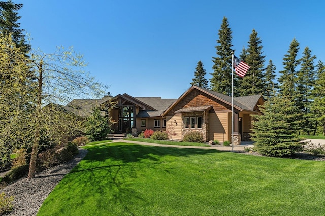craftsman-style home featuring stone siding and a front yard