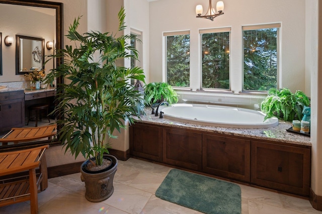 bathroom with marble finish flooring, a bath, a chandelier, and vanity