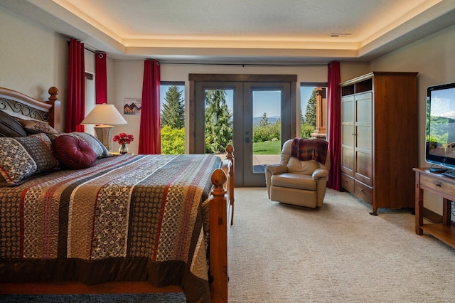 bedroom with access to outside, french doors, a raised ceiling, and carpet