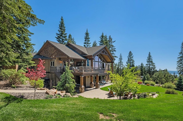 rear view of property featuring a lawn, stairway, a patio area, and a wooden deck