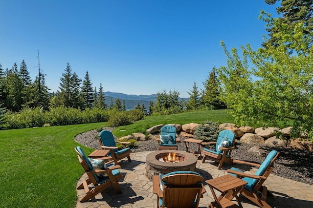view of patio / terrace with a fire pit and a mountain view