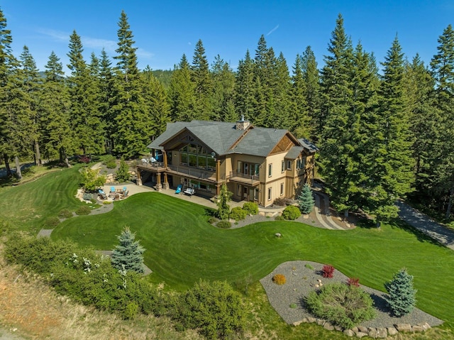 aerial view of property and surrounding area featuring a forest