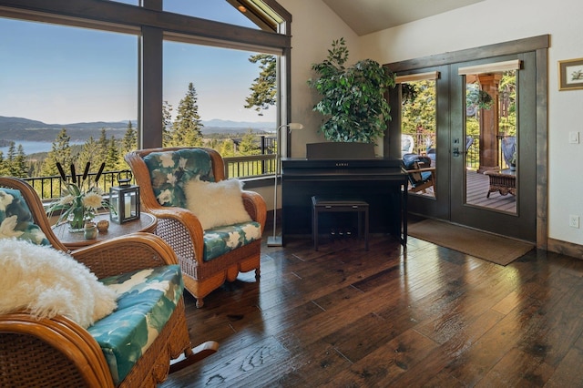 living area featuring a mountain view, lofted ceiling, french doors, wood-type flooring, and baseboards