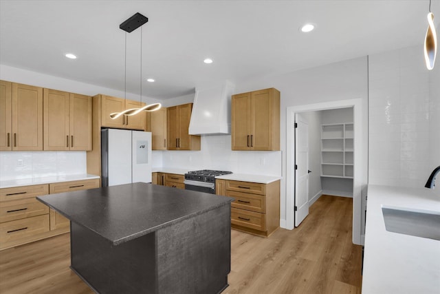 7025 E Beverly Ave, Spokane Valley, WA 99212 - kitchen with freestanding refrigerator, custom exhaust hood, a sink, stainless steel range with gas cooktop, and decorative backsplash