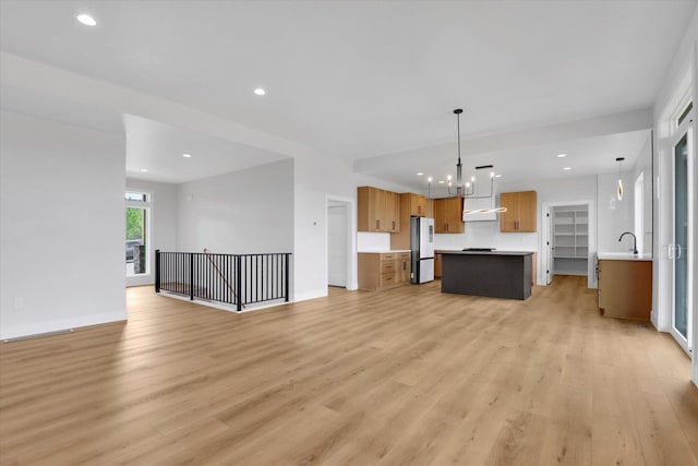 7025 E Beverly Ave, Spokane Valley, WA 99212 - unfurnished living room featuring light wood-style floors, a chandelier, recessed lighting, and baseboards