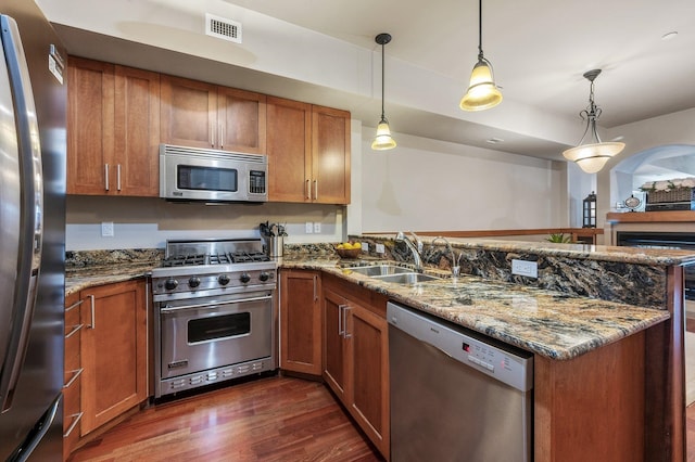 316 S 10th Pl, Coeur D Alene, ID 83814 - kitchen featuring stainless steel appliances, a peninsula, a sink, and brown cabinetry