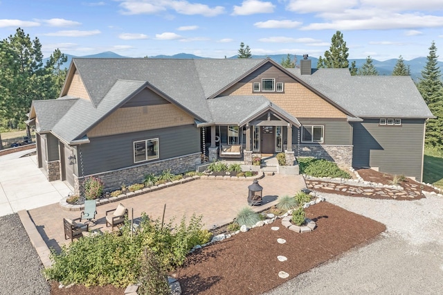 11818 N Mountain Trail Ln, Spokane, WA 99217 - craftsman-style house featuring covered porch, stone siding, a chimney, concrete driveway, and an attached garage