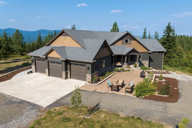 11818 N Mountain Trail Ln, Spokane, WA 99217 - craftsman-style home with a garage, stone siding, driveway, a mountain view, and covered porch