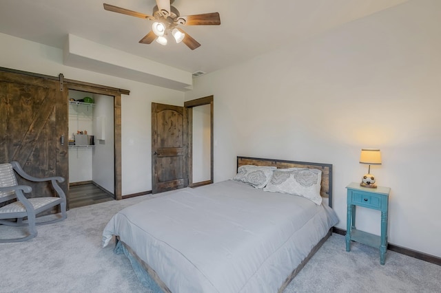 11818 N Mountain Trail Ln, Spokane, WA 99217 - carpeted bedroom featuring a barn door, baseboards, a closet, and ceiling fan