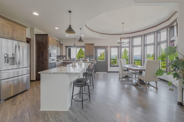 11818 N Mountain Trail Ln, Spokane, WA 99217 - kitchen featuring stainless steel appliances, recessed lighting, a center island, wood finished floors, and light stone countertops