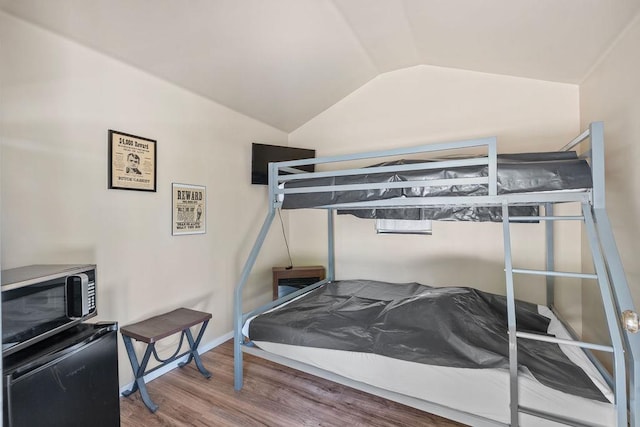 91 Moonlight Ln, Newport, WA 99156 - bedroom with wood finished floors, lofted ceiling, fridge, and baseboards