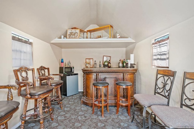 91 Moonlight Ln, Newport, WA 99156 - indoor dry bar featuring stainless steel microwave, healthy amount of natural light, vaulted ceiling, refrigerator, and carpet