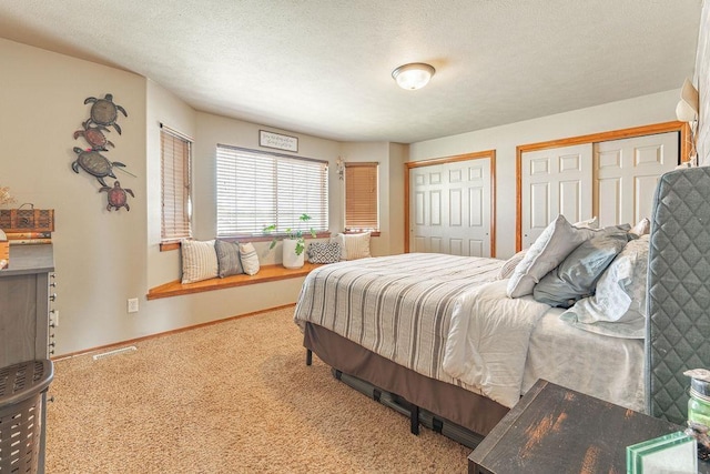 bedroom with multiple closets, carpet floors, and baseboards