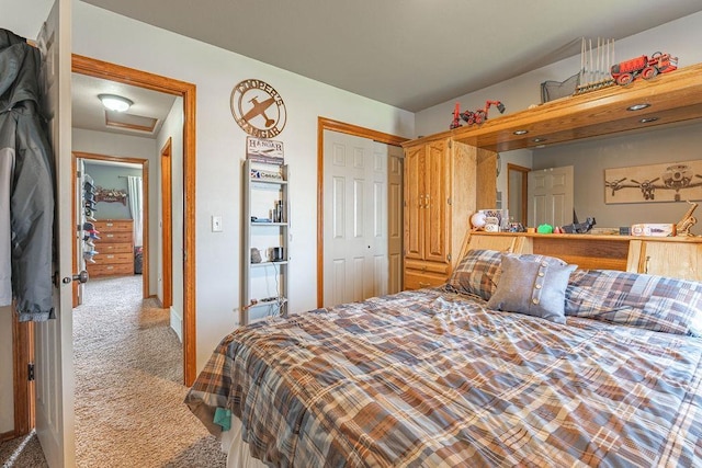 bedroom with attic access, carpet flooring, and a closet