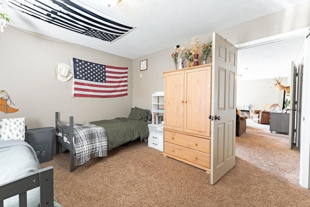 bedroom featuring light colored carpet and a textured ceiling