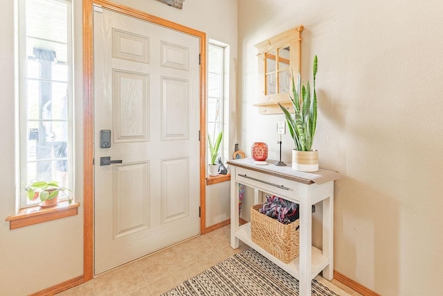entrance foyer with plenty of natural light, light tile patterned floors, and baseboards