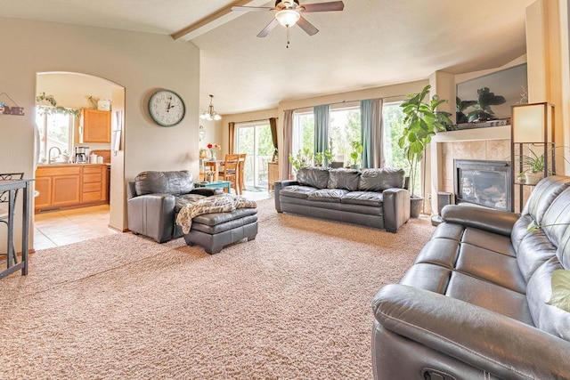 living area featuring ceiling fan, a fireplace, and light colored carpet