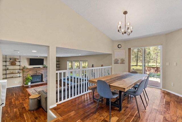 7007 N Tucannon Ct, Spokane, WA 99208 - dining space with a chandelier, hardwood / wood-style flooring, a brick fireplace, and high vaulted ceiling