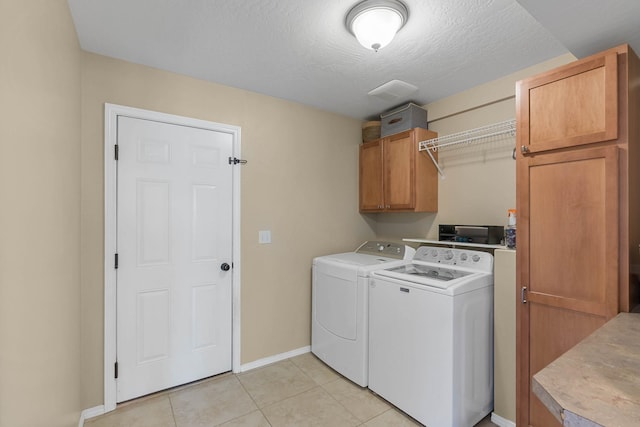 7007 N Tucannon Ct, Spokane, WA 99208 - laundry area with cabinet space, separate washer and dryer, light tile patterned flooring, and a textured ceiling