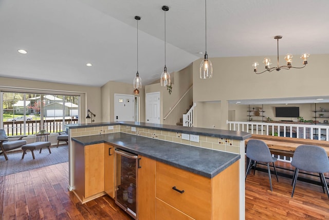7007 N Tucannon Ct, Spokane, WA 99208 - kitchen with beverage cooler, dark countertops, dark wood-type flooring, open floor plan, and vaulted ceiling