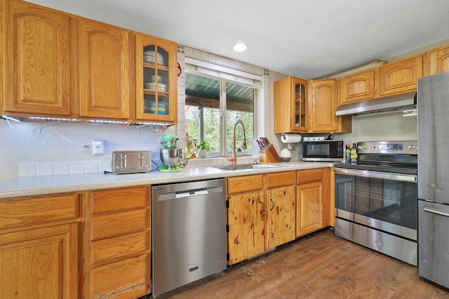 15205 N Scribner Branch Rd, Spokane, WA 99217 - kitchen featuring stainless steel appliances, under cabinet range hood, a sink, dark wood-style floors, and light countertops