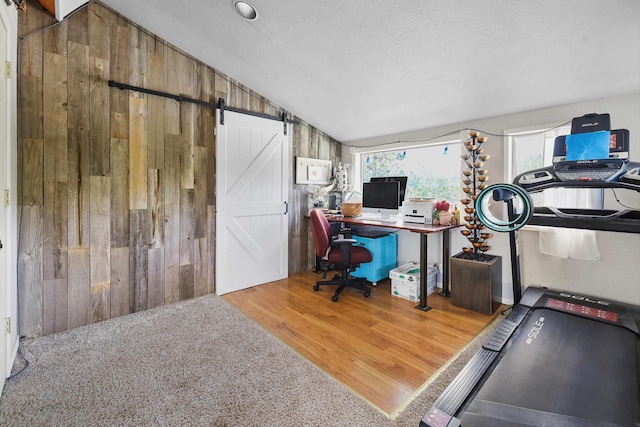15205 N Scribner Branch Rd, Spokane, WA 99217 - office with wooden walls, wood finished floors, vaulted ceiling, a barn door, and a textured ceiling