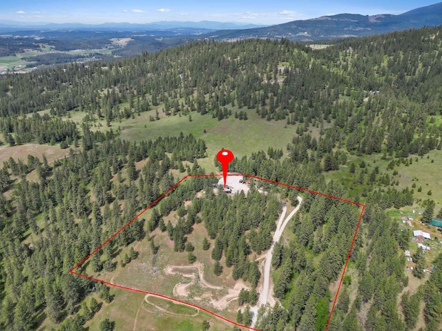 15205 N Scribner Branch Rd, Spokane, WA 99217 - aerial view of property's location with a heavily wooded area, property parcel outlined, and a mountain backdrop