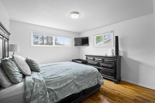 bedroom with wood finished floors and baseboards