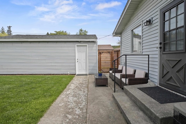 view of grassy yard featuring outdoor lounge area, a patio, and an outbuilding