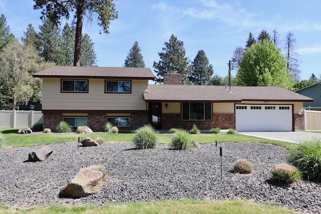 13703 E 31st Ave, Spokane Valley, WA 99216 - tri-level home featuring an attached garage, brick siding, driveway, and a chimney