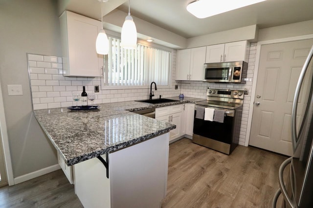 13703 E 31st Ave, Spokane Valley, WA 99216 - kitchen featuring appliances with stainless steel finishes, a sink, a peninsula, and white cabinetry